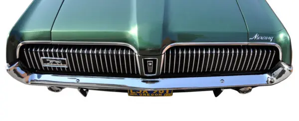 A close up of the front bumper and grill on an old car.