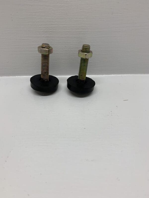 Two black rubber feet with a metal nut and bolt.