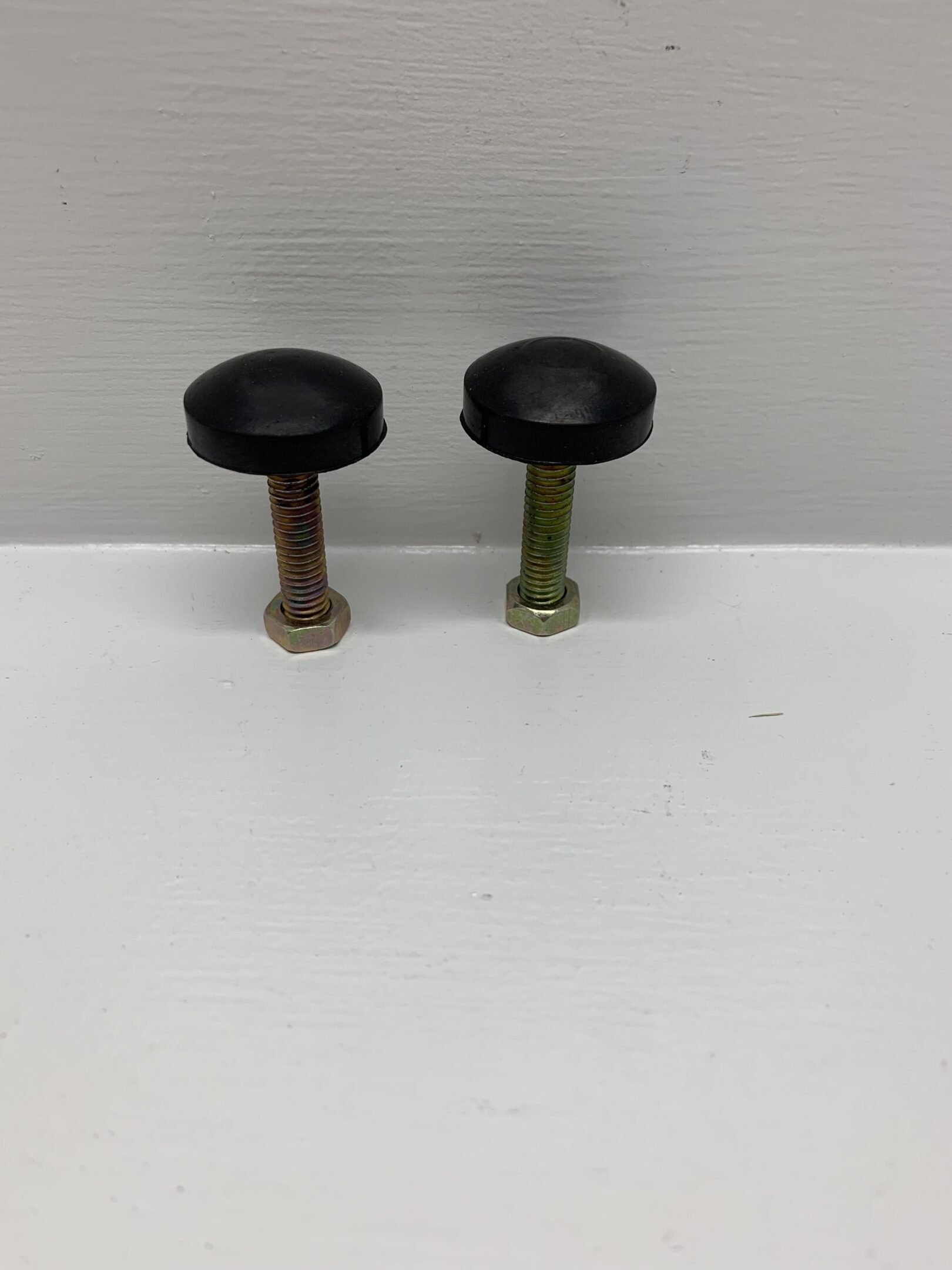 Two black knobs sitting on top of a table.