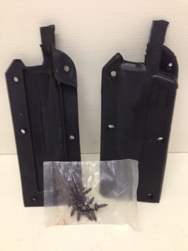 A pair of black metal brackets next to a bag.