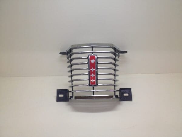 A chrome grill with red lettering on it.