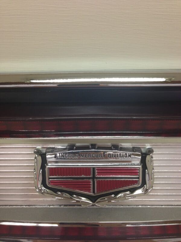 A close up of the hood emblem on an old car.