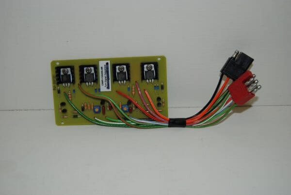 A green board with four different wires connected to it.