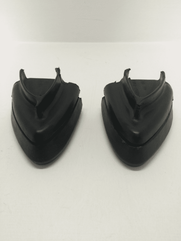 A pair of black plastic shields on top of a white wall.