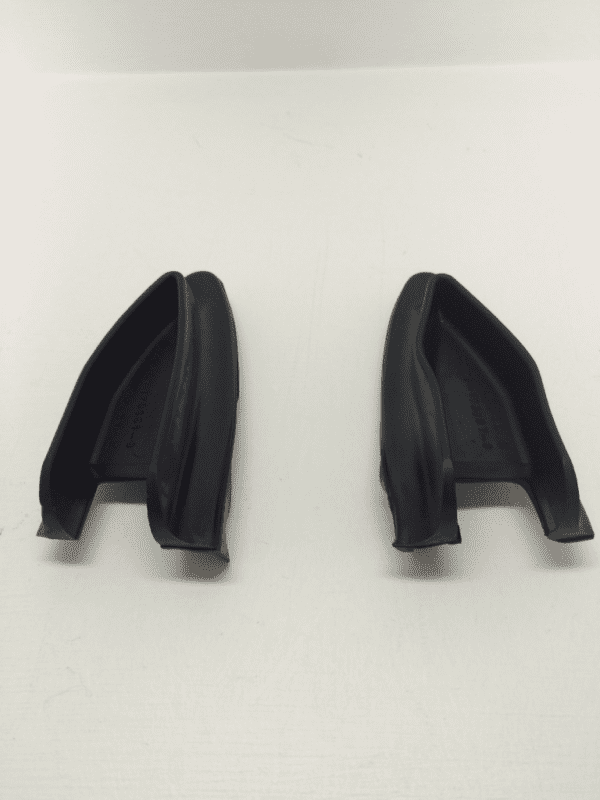 A pair of black plastic handles on a white surface.