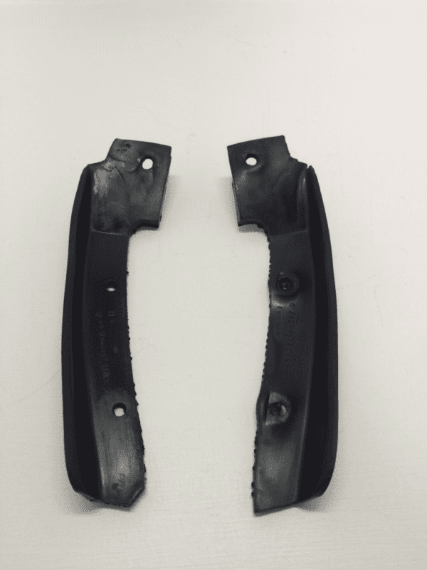 A pair of black plastic handles on top of a white surface.