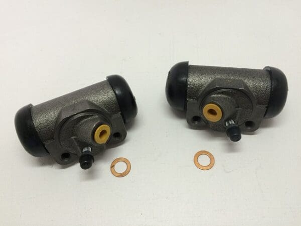 A pair of brake cylinders with two copper washers.