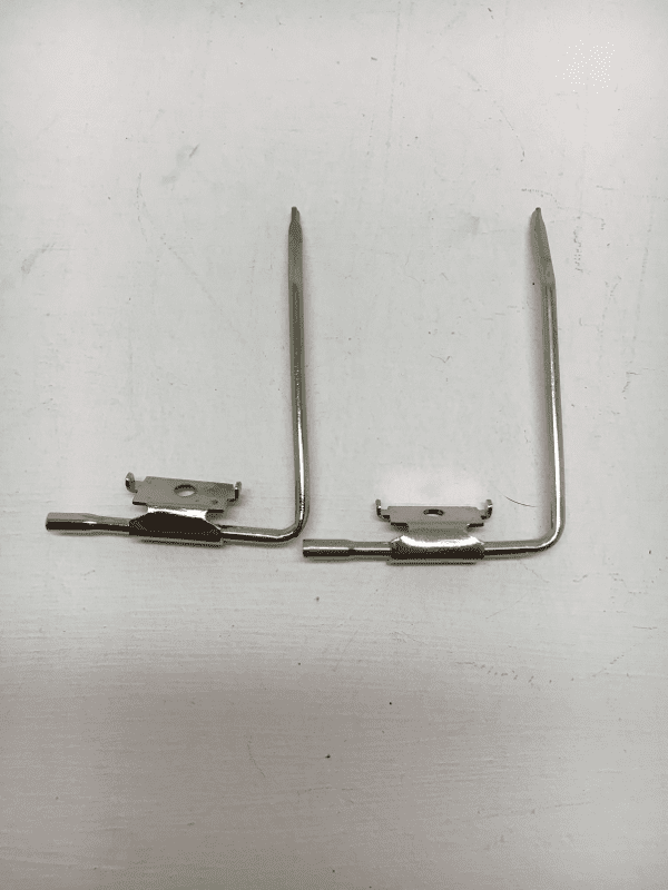 A pair of metal hooks with one holding something.