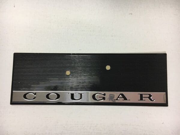 A black and silver plaque with the word cougar on it.