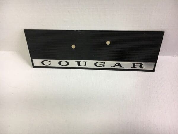 A black and white sign with the word cougar on it.