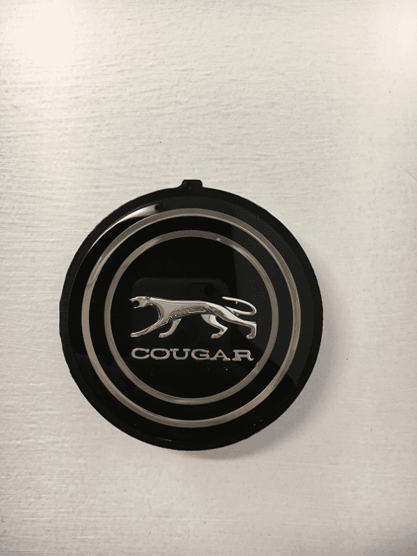 A black and silver cougar logo on the side of a wall.