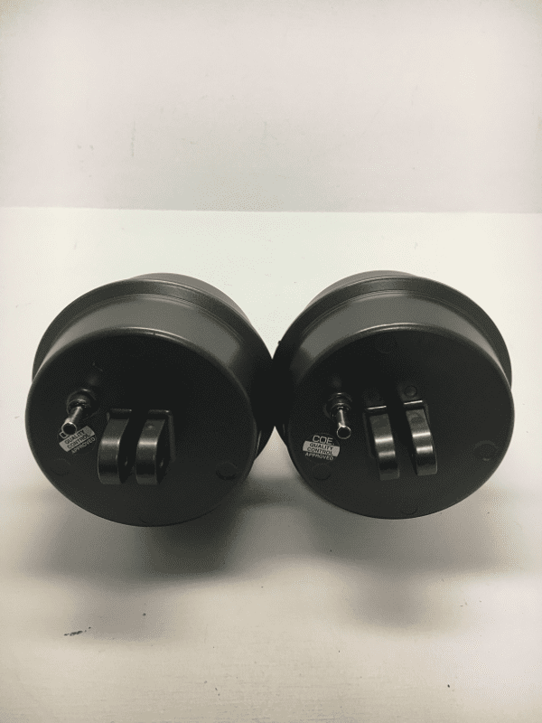 A pair of black knobs sitting on top of a table.