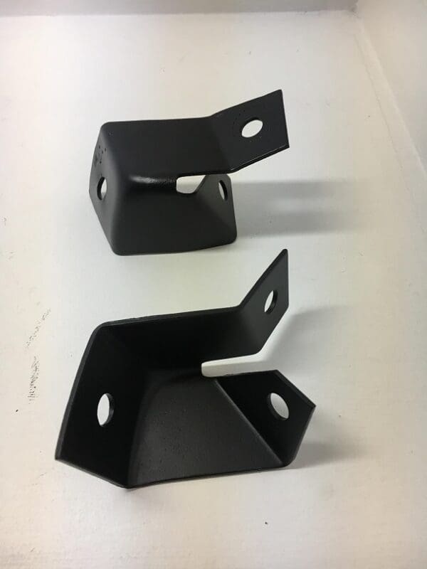 A pair of black metal brackets sitting on top of a table.