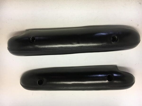 A pair of black plastic handles on top of white paper.