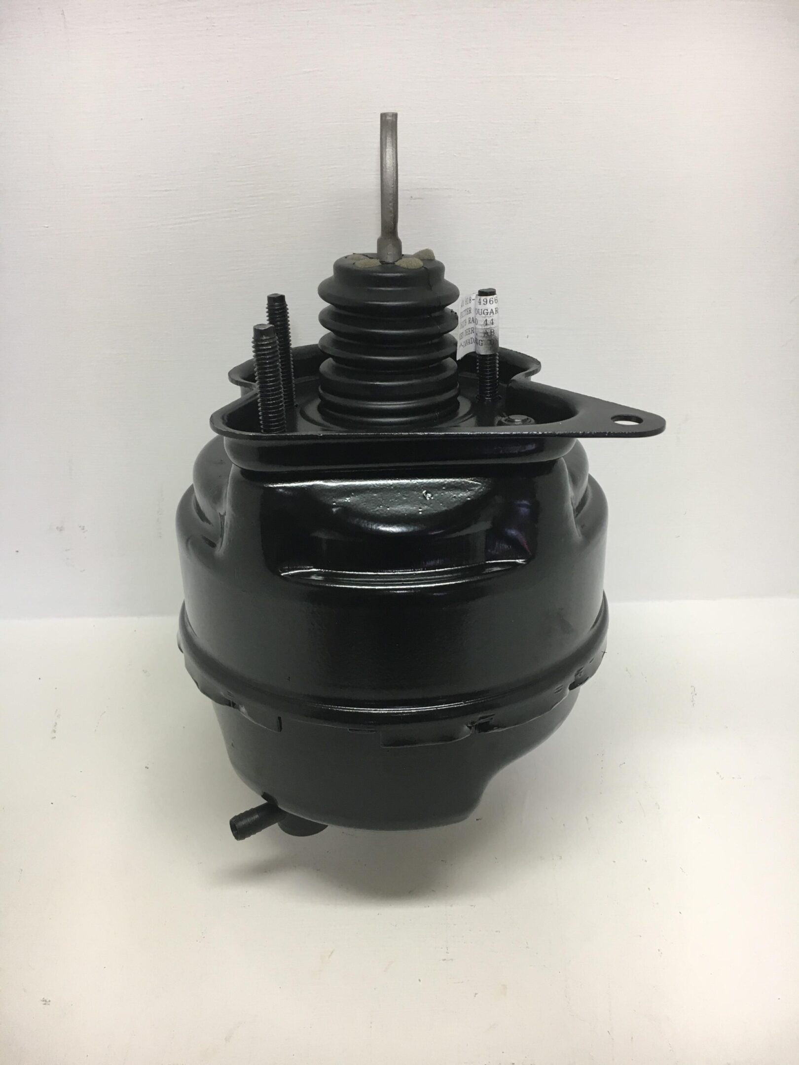 A black car brake booster on top of a white table.