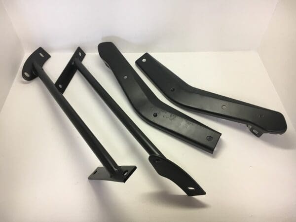 A set of four black metal brackets sitting on top of a table.