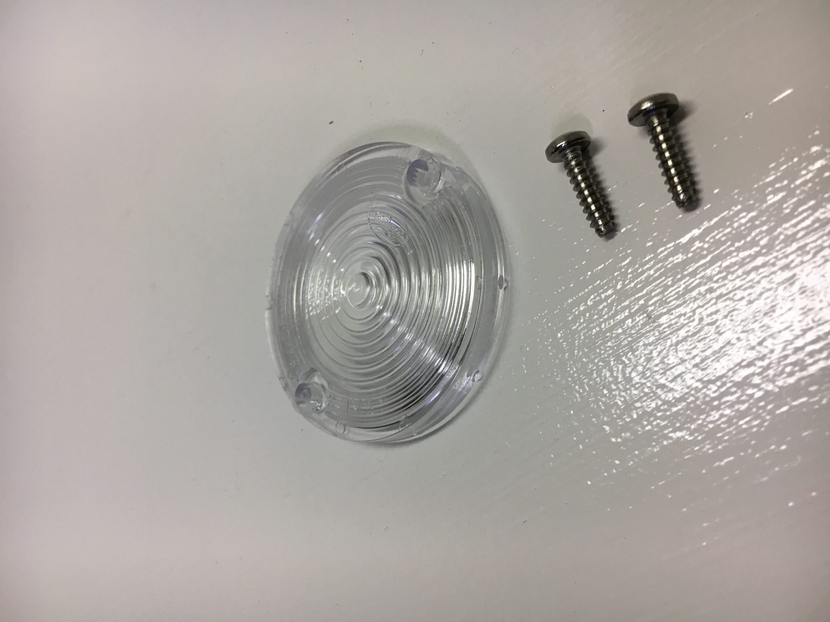 A white table with some metal screws and a plastic object