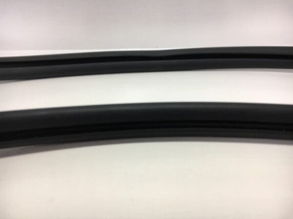 A pair of black rubber hoses on top of a white table.