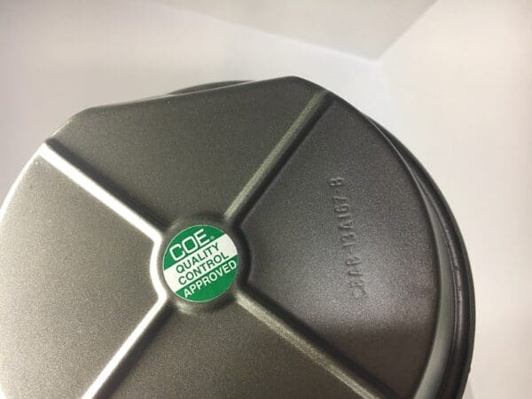 A close up of the lid on a green and silver container.