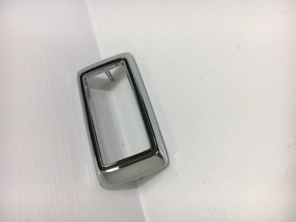 A silver object sitting on top of a white surface.