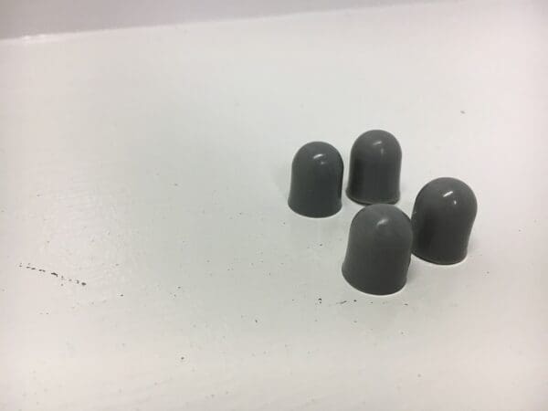 A group of four gray caps sitting on top of a table.