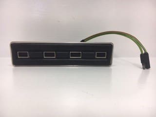 A black box with four ports and a green cord.