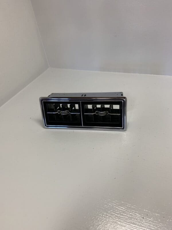 A small black and silver object on top of a white table.