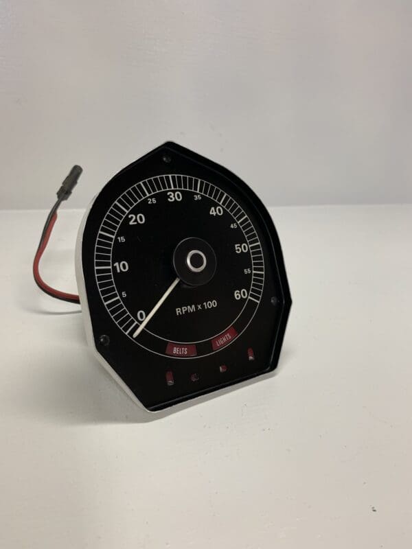 A speedometer with wires attached to it.