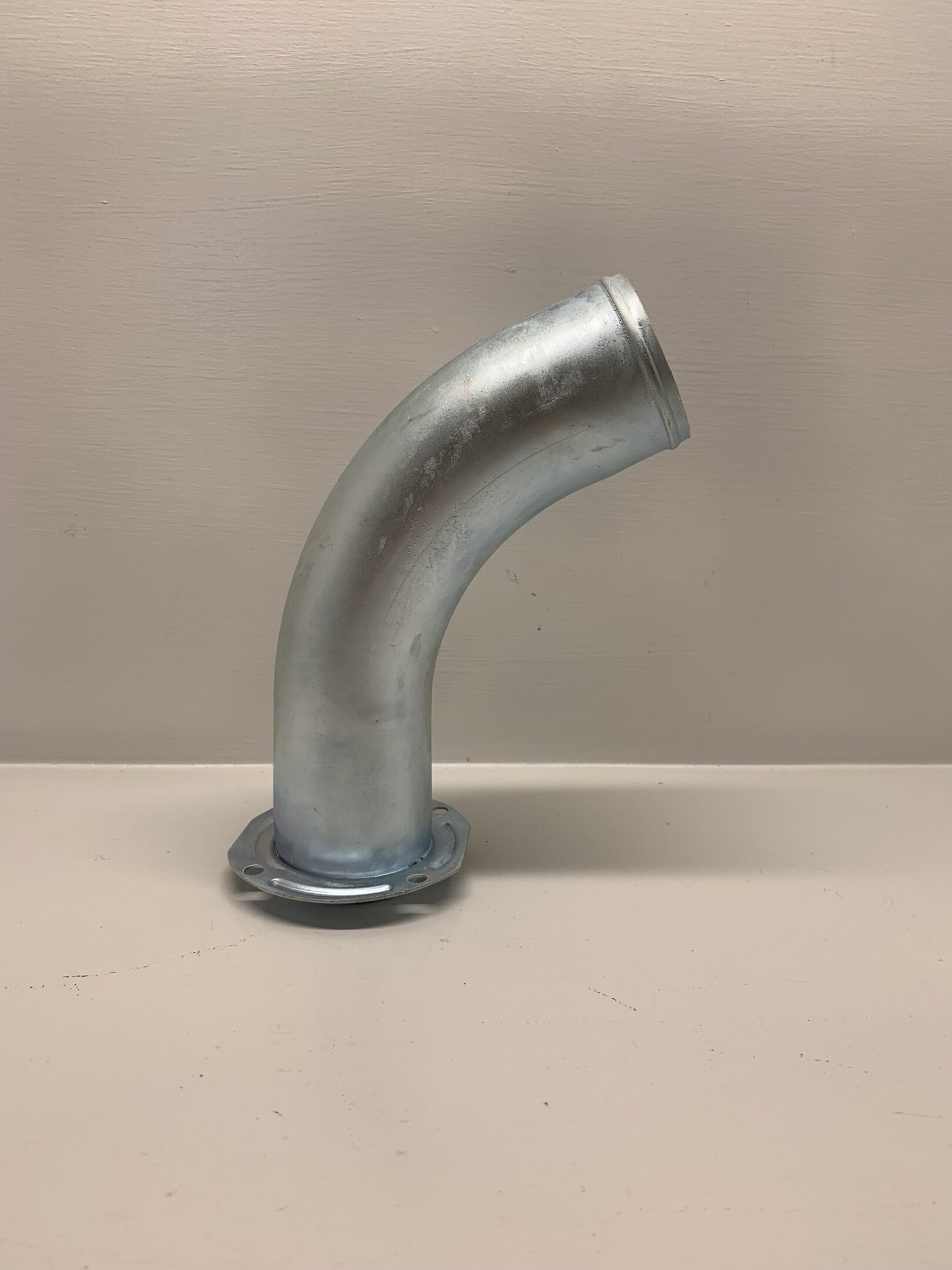 A metal pipe sitting on top of a table.