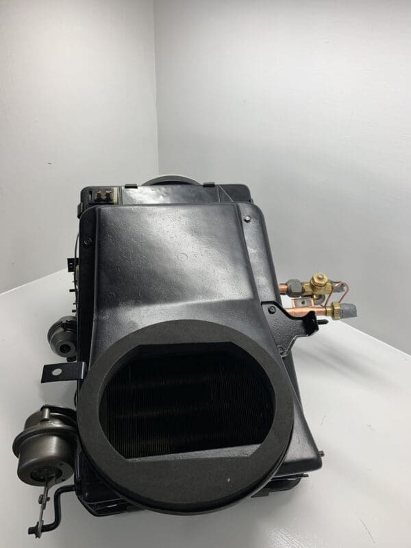 A black car engine sitting on top of a white table.