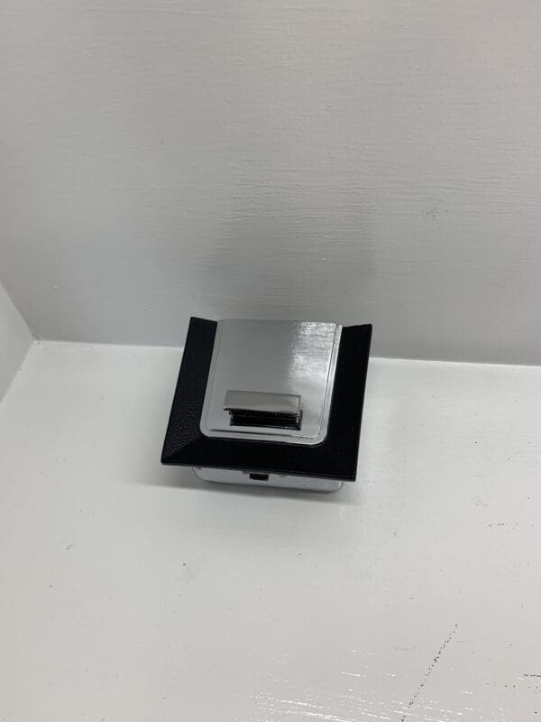 A square shaped object sitting on top of a white table.