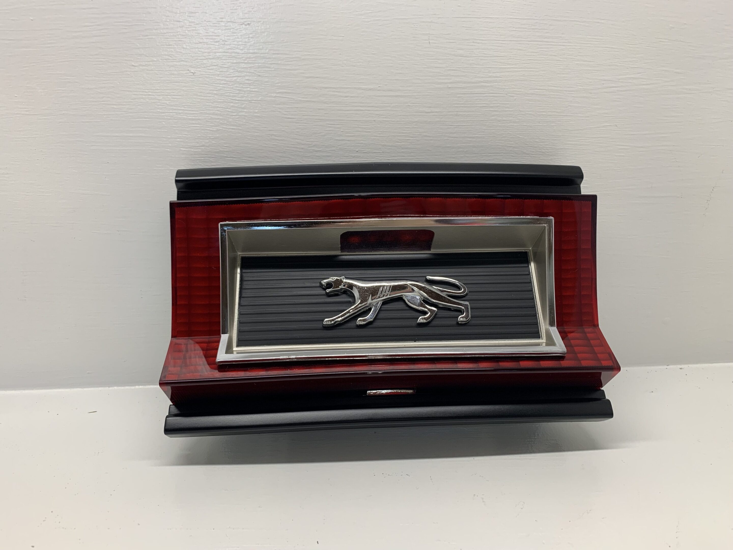 A red and black dog shaped business card holder.