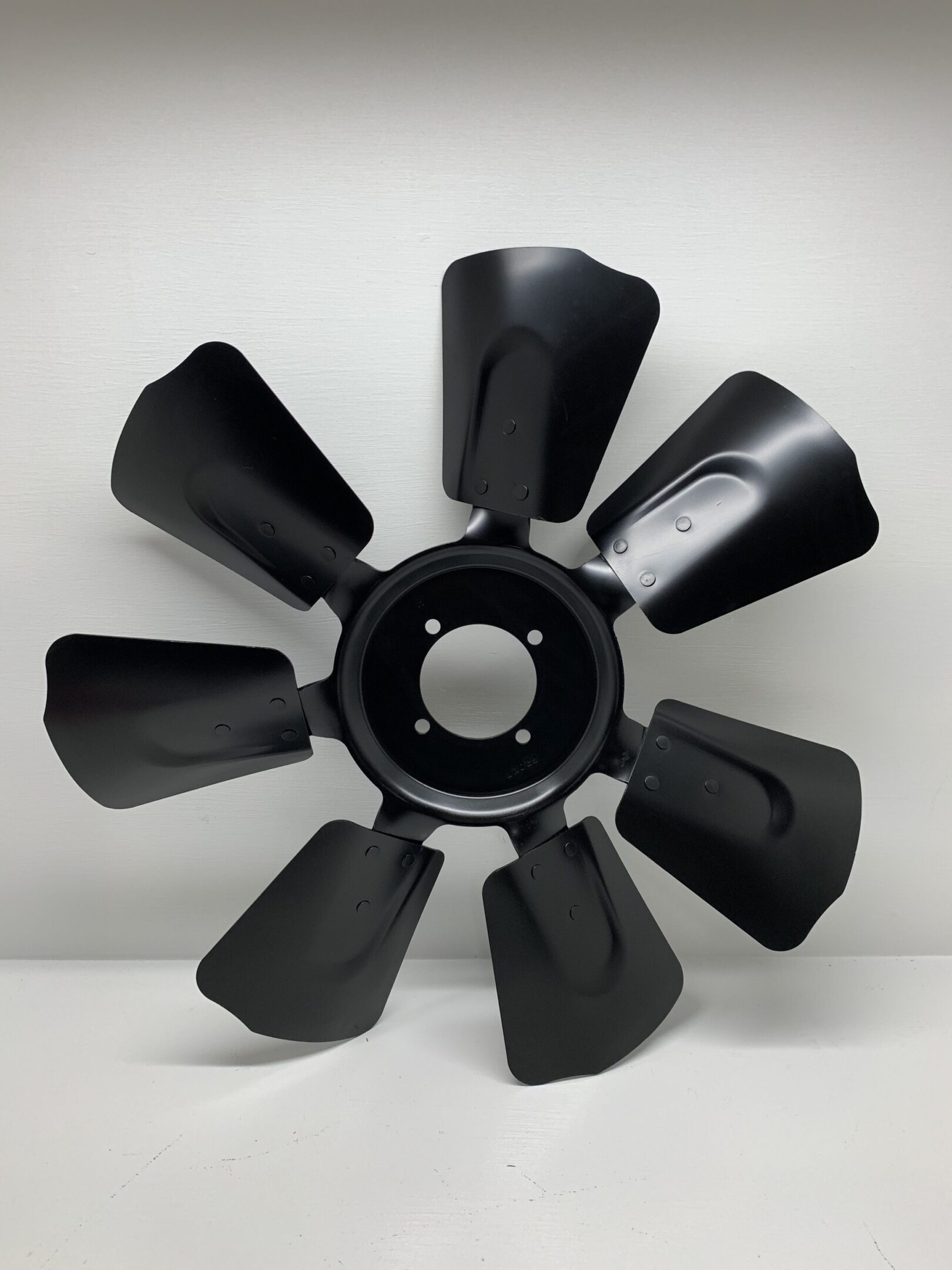 A black fan blade is shown on the wall.