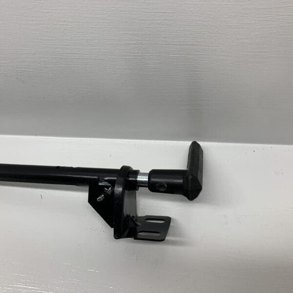 A black curtain rod with a metal clip on it.