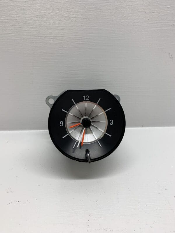 A black and white clock is sitting on the wall