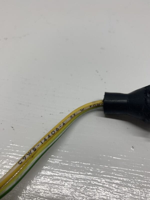 A yellow and black wire is connected to an electrical cord.