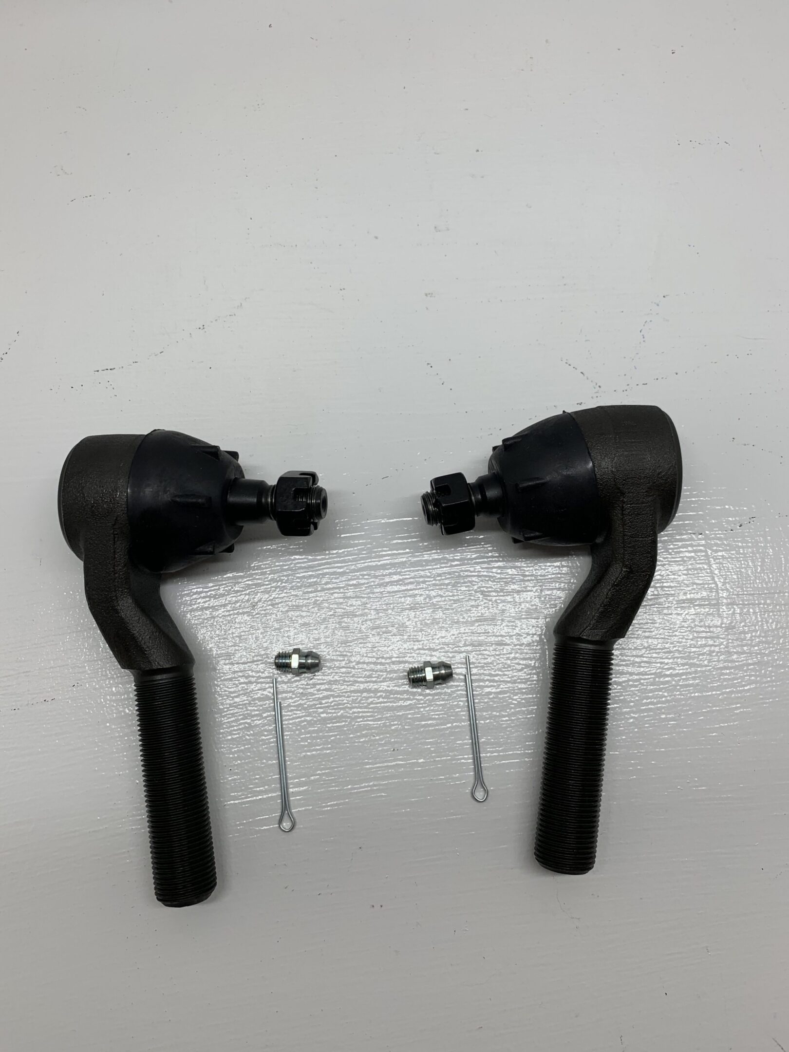 A pair of black steering rods with two pins.