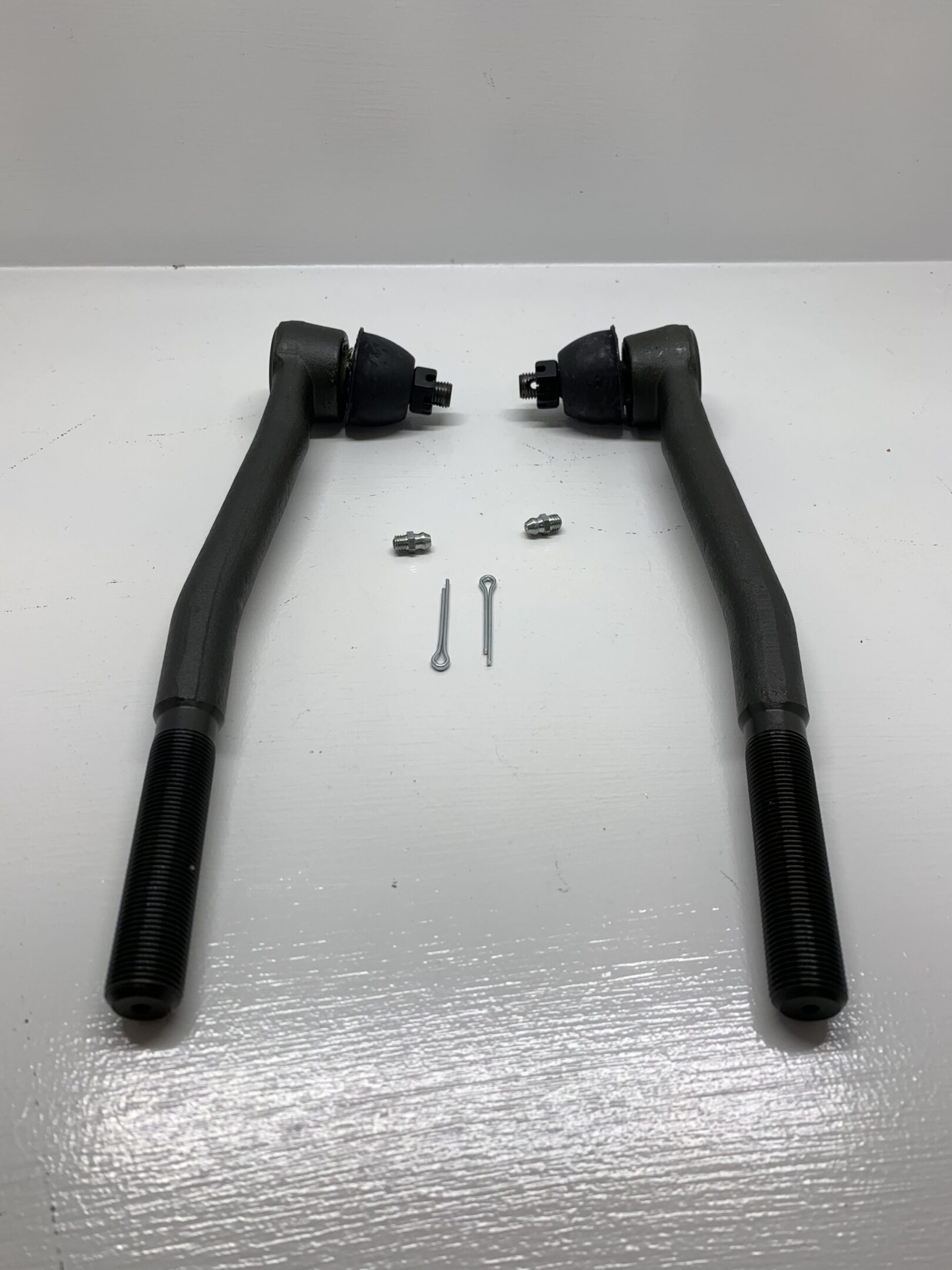 A pair of black tie rods and ball joints.