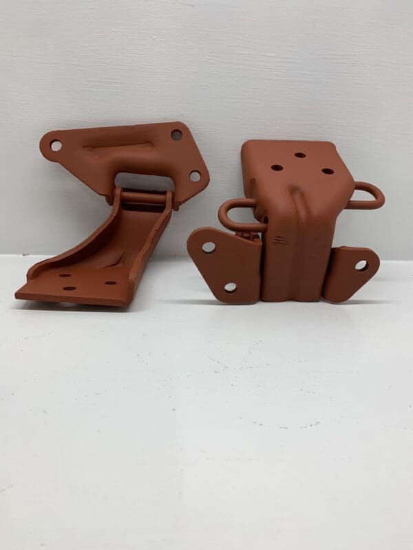 A pair of rust colored plastic parts sitting on top of a table.