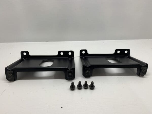 A pair of black metal brackets with screws.