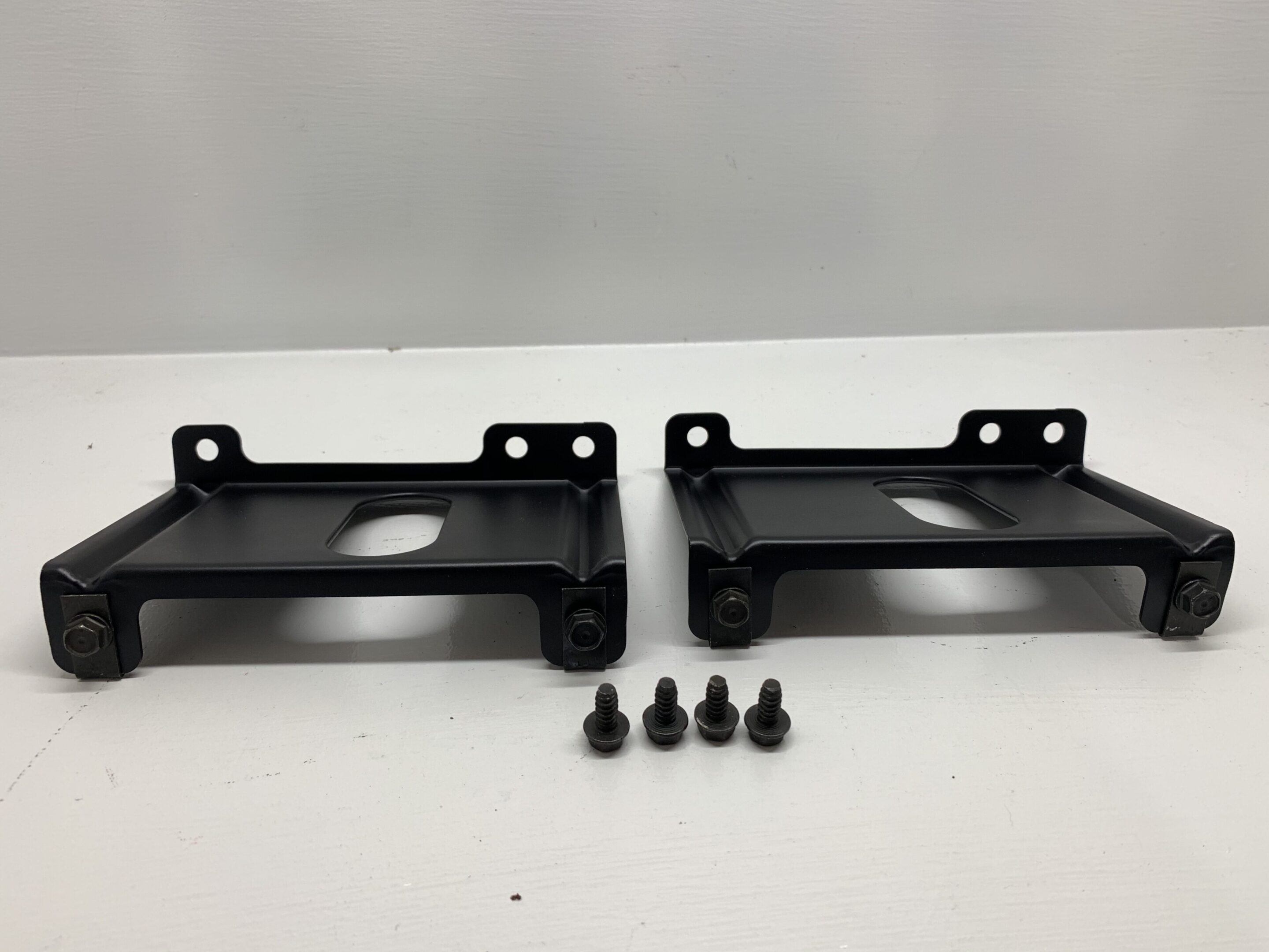 A pair of black metal brackets with screws.