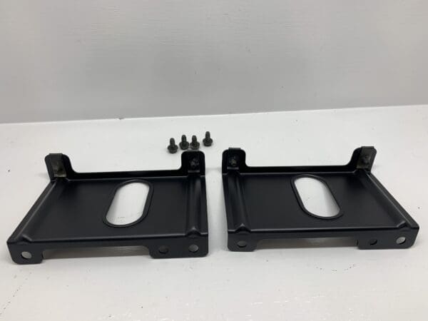 A pair of black metal brackets sitting on top of a table.